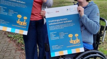 Zwei Personen präsentieren Poster des EUTB-Angebots in Northeim.