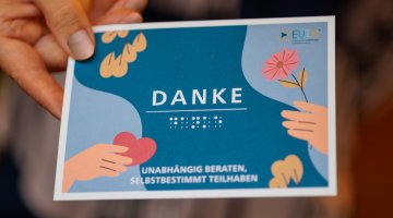 Postkarte mit EUTB-Logo und Danke-Schriftzug und Brailleschrift